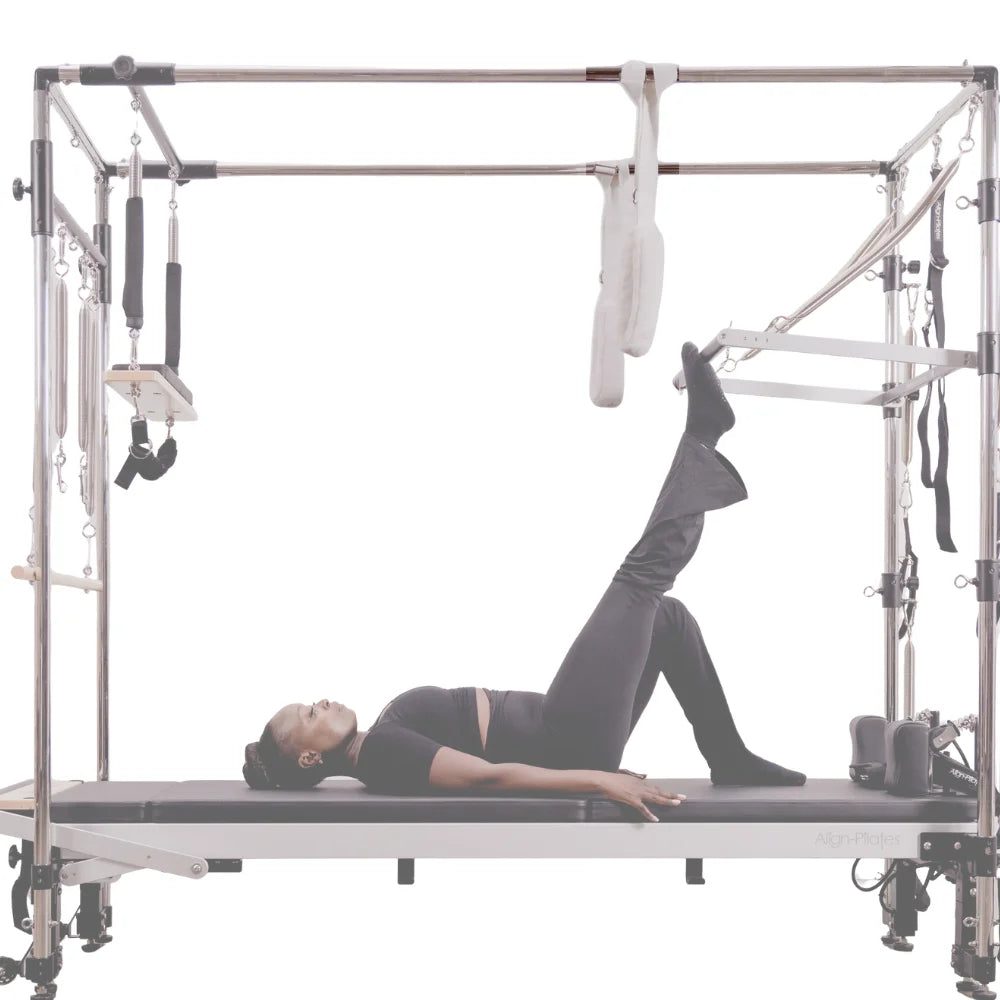 Person using a Pilates reformer with full trapeze on a white background