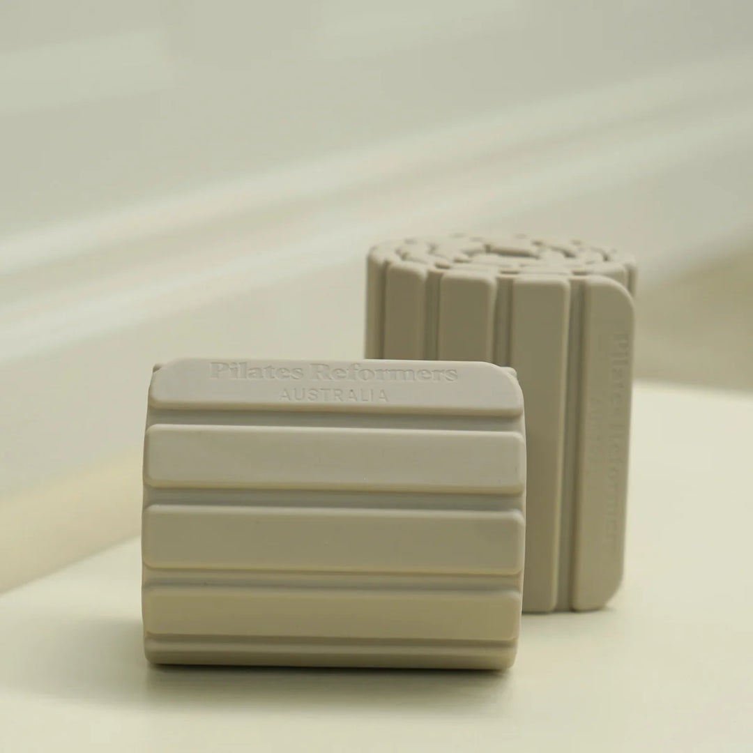 Two beige magnetic weights on a light surface