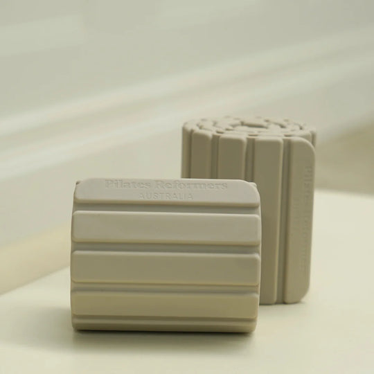 Two beige magnetic weights on a light surface